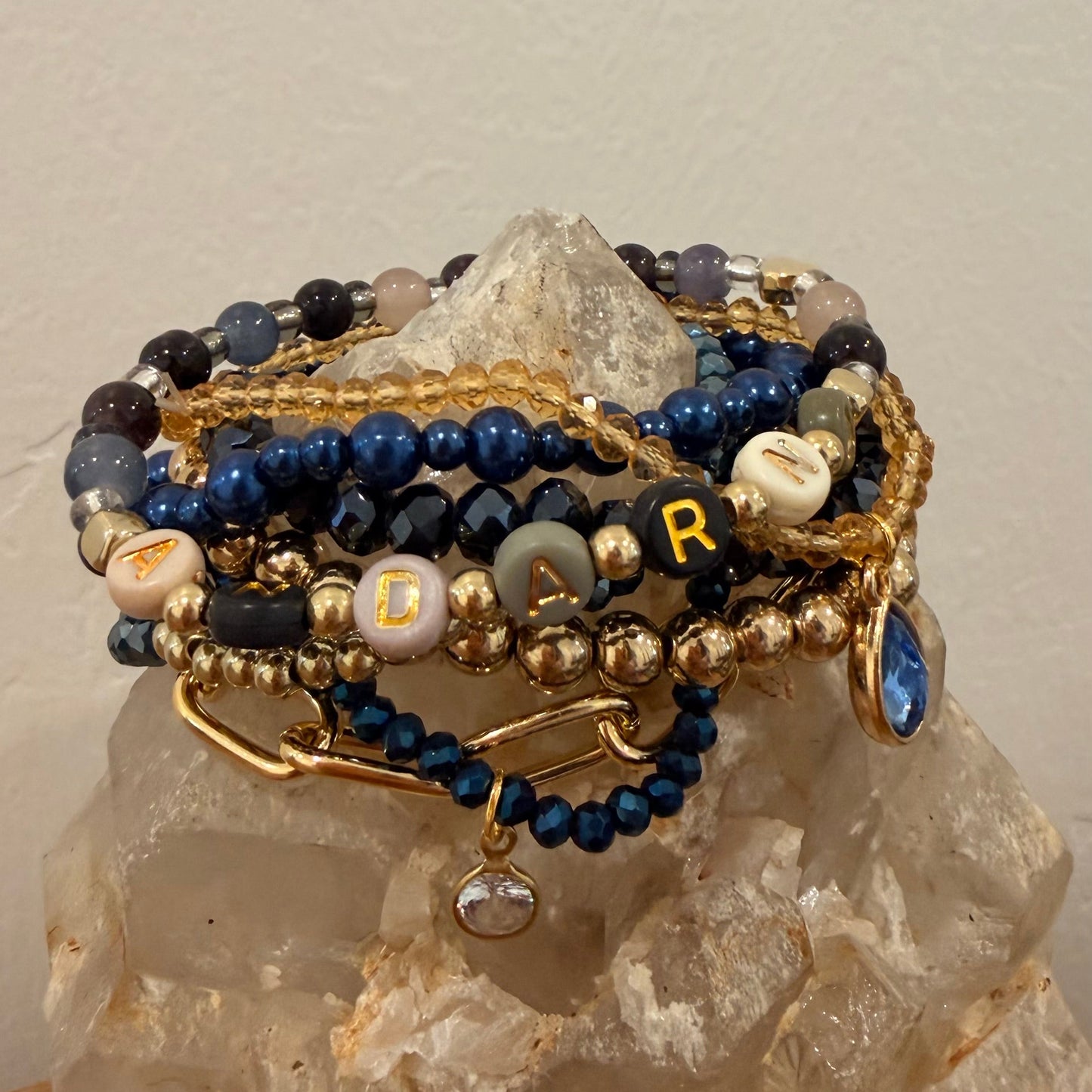 Stack of beaded bracelets on a crystal with a neutral background