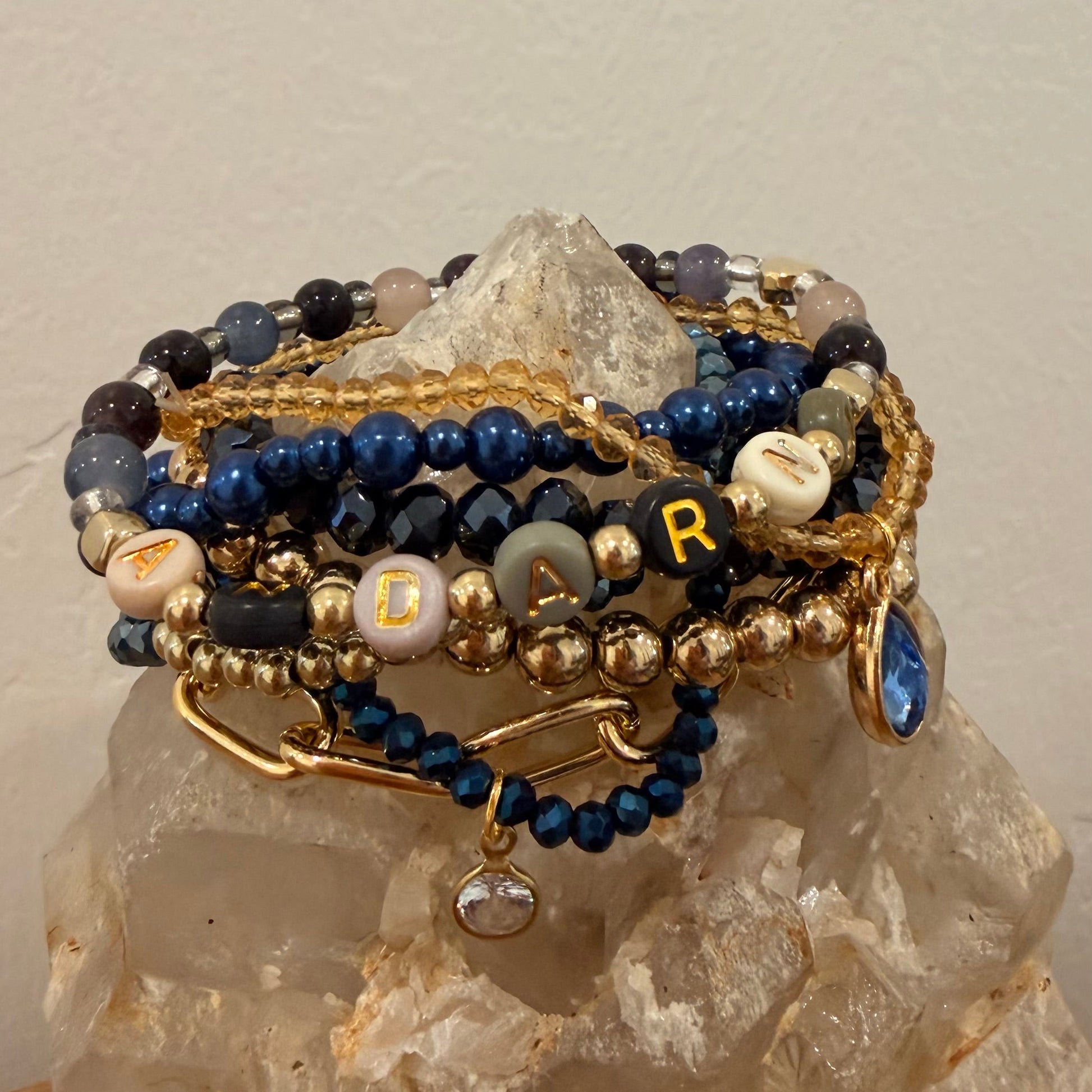 Stack of beaded bracelets on a crystal with a neutral background