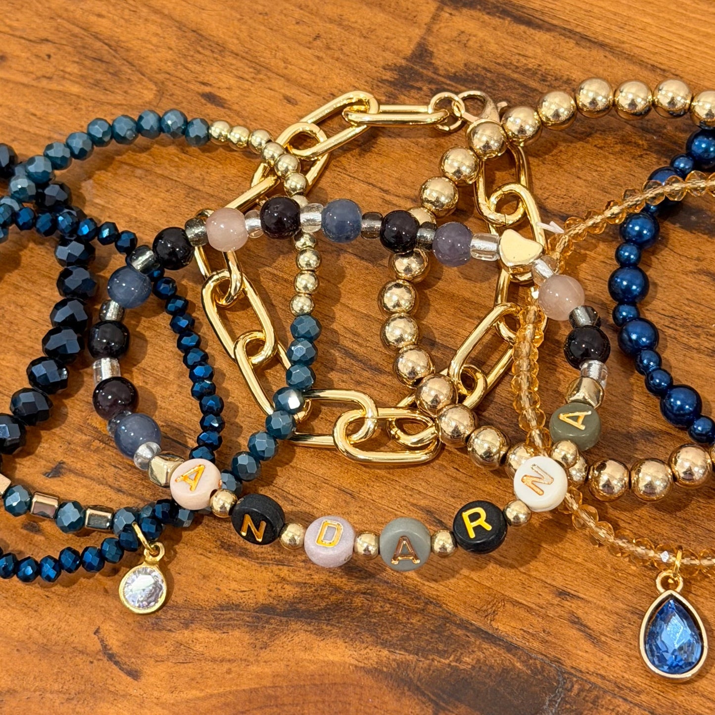 Set of beaded and chain bracelets on a wooden surface